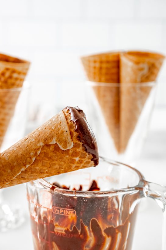 Dipping the cones in the melted chocolate to make the Ice Cream Cannoli Cones recipe