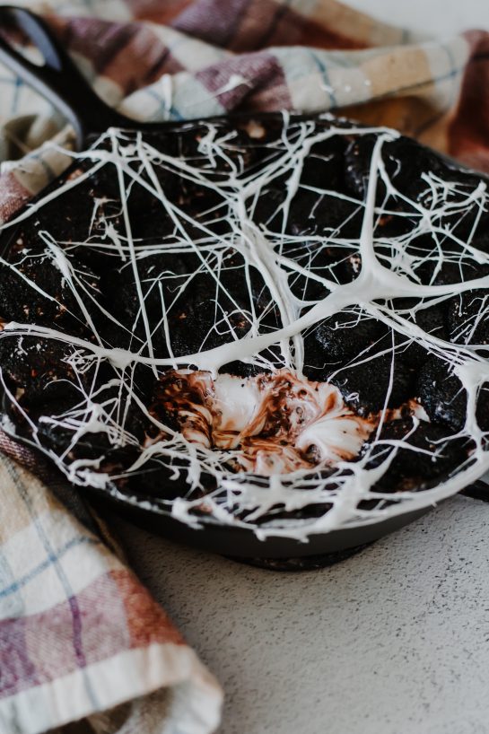 Spooky Spiderweb S'mores Dip recipe needs only a few ingredients, takes minutes to make, and is a super-fun Halloween party food idea! Creamy melted white chocolate topped with toasted marshmallows served with graham crackers, cookies, or fruit for dipping.