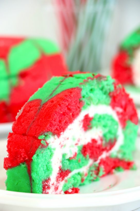 This Christmas Cake Roll is the perfect Holiday Dessert recipe for your friends and family! This cake is so simple to make for the holidays and a fun twist on traditional cake, with the festive colors and look of Christmas!