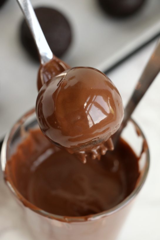 Dipping the cake balls in the melted chocolate for the Easy Turkey Cake Pops recipe