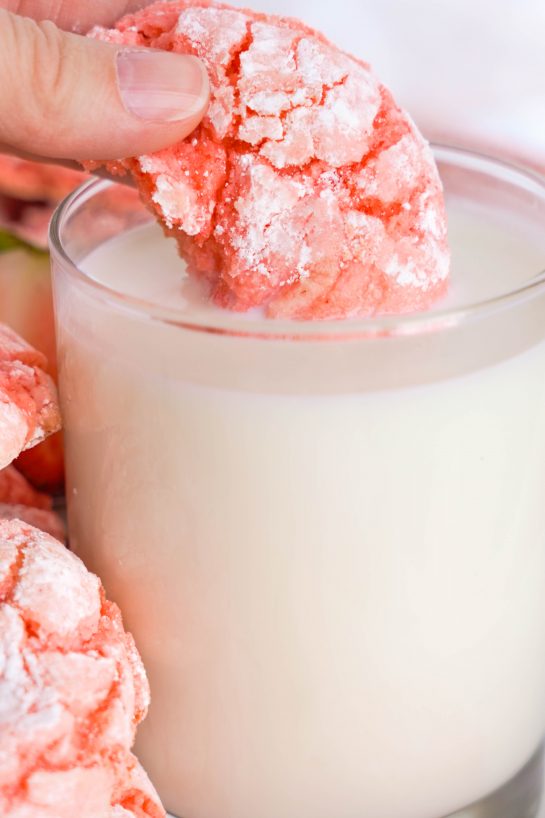 Image of dunking one of the Strawberry Crinkle Cookies in milk for Valentine's Day party