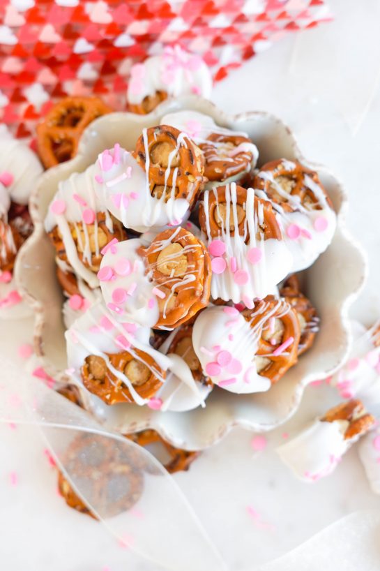 Valentine's Day Pretzel Bites recipe is so easy to make for any holiday, it's no wonder they're a classic! Two pretzels that are stuffed with a peanut butter filling and dipped in white chocolate coating. Great for edible gifts and parties!