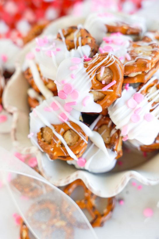 Valentine's Day Pretzel Bites recipe is so easy to make for any holiday, it's no wonder they're a classic! Two pretzels that are stuffed with a peanut butter filling and dipped in white chocolate coating. Great for gifts and parties!