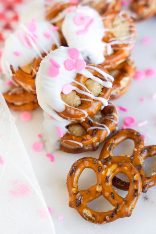Easy Valentine's Day Pretzel Bites recipe is so fun to make for any holiday, it's no wonder they're a classic! Two pretzels that are stuffed with a peanut butter filling and dipped in white chocolate coating. Great for gifts and parties!