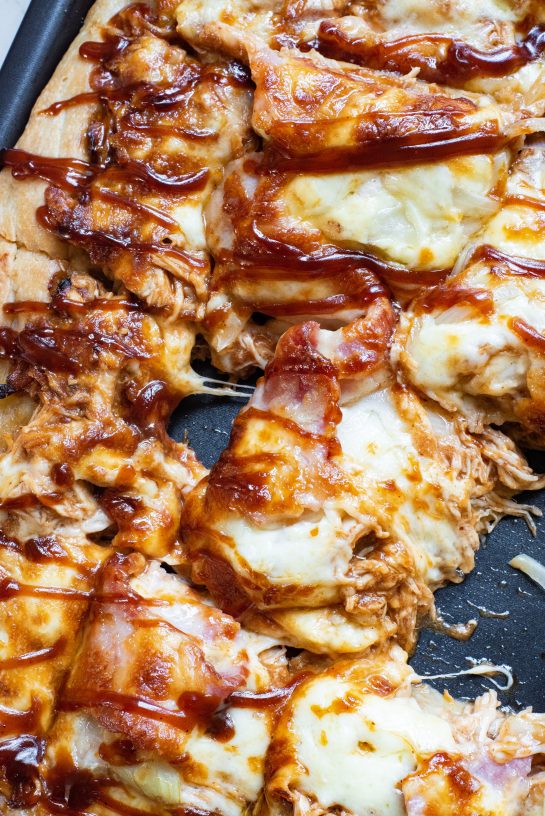 Sweet and savory Sheet Pan BBQ Chicken Pizza recipe has a crispy crust, tons of cheese, and tender chicken, with the sweetness of hickory barbecue sauce. It’s a so simple to make for a holiday, party or weeknight dinner!