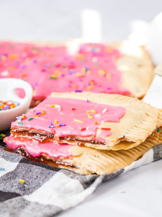 Easy Sheet Pan Strawberry Poptarts is a great dessert recipe everyone will love. Pie Crust and strawberry jam give this dessert it's famous pop-tart flavor. These pop tarts are filled with REAL strawberry jam and topped with rainbow sprinkles. 