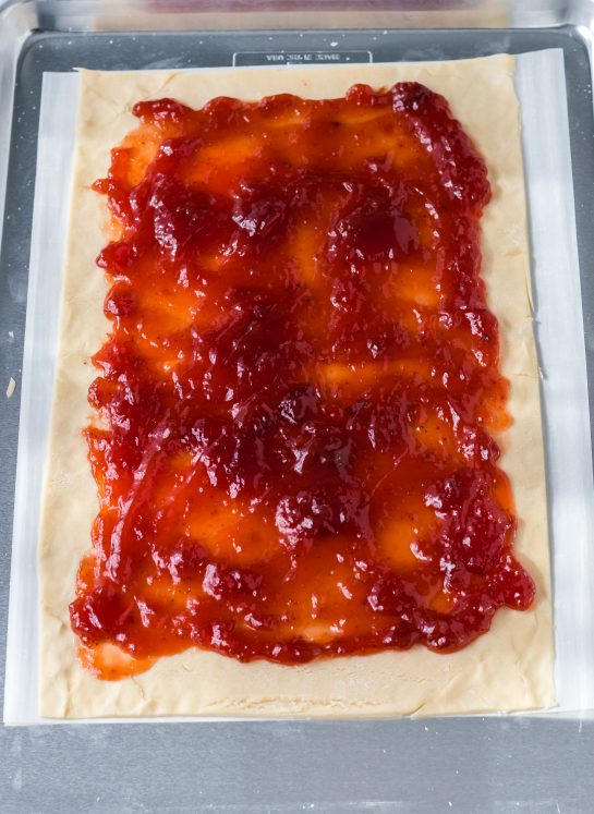 Spreading the jam onto the dough for the sheet pan strawberry poptarts recipe
