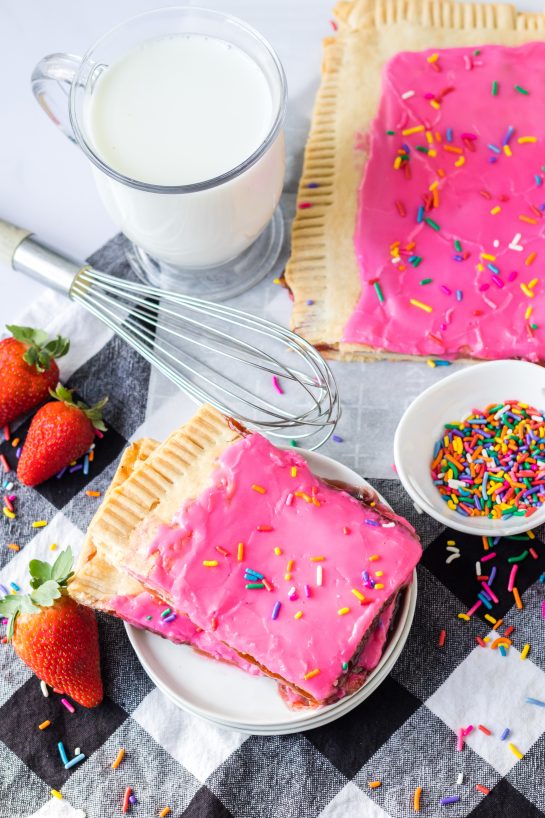 Sheet Pan Strawberry Poptarts is a great dessert or breakfast recipe everyone will love. Pie Crust and strawberry jam give this dessert it's famous pop-tart flavor. These pop tarts are filled with homemade strawberry jam and topped with rainbow sprinkles. 