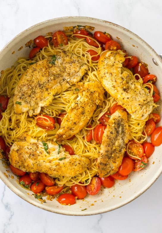 Adding the seasoned chicken to the tomato mixture for the Bruschetta Chicken Pasta recipe 