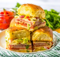 This Italian Sub Sliders recipe combines ham, salami, pepperoni and provolone, then gets baked until melty. Top them with your favorite toppings and mayo and you have yourself a party crowd-pleaser!
