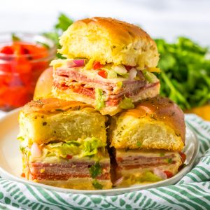 This Italian Sub Sliders recipe combines ham, salami, pepperoni and provolone, then gets baked until melty. Top them with your favorite toppings and mayo and you have yourself a party crowd-pleaser!