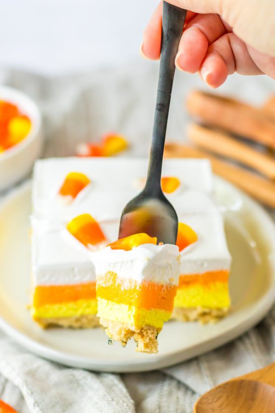 Close-up of a slice of the Candy Corn Lush recipe that is always a favorite at parties and is a make-ahead fall Halloween dessert that’ll make all ghouls go wild!