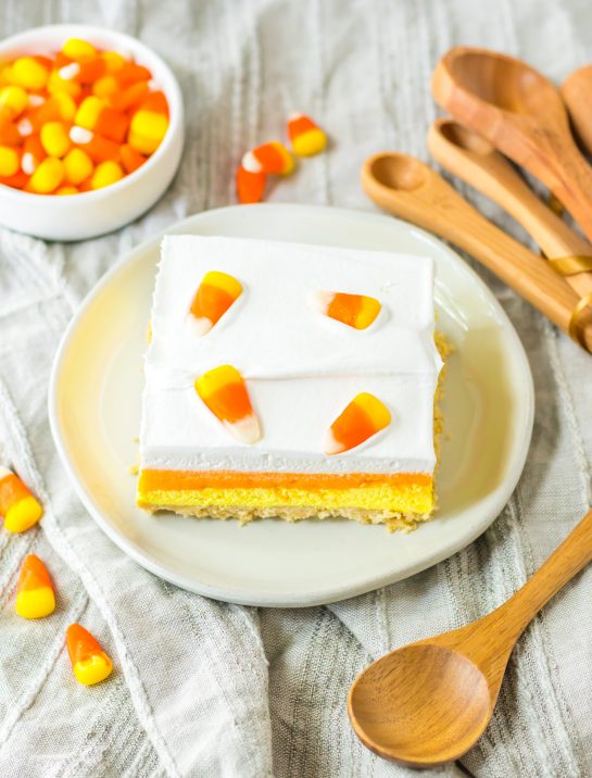 Overhead photo of a slice of the Candy Corn Lush recipe that is always a favorite at parties and is a make-ahead fall Halloween dessert that’ll make all ghouls go wild!