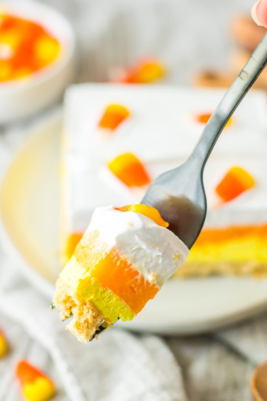 Close-up of a slice of the Candy Corn Lush recipe that is always a favorite at parties and is a make-ahead fall Halloween dessert.