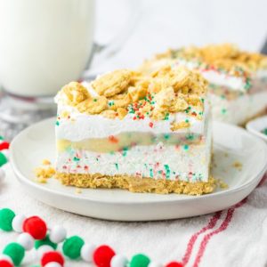 Christmas Cookie Lush is the perfect holiday dessert.  This is no-bake, so it makes for a quick dessert when you are entertaining. Layers of vanilla cream cookies and sprinkles, a cheesecake layer, finished off with a pudding layer, whipped topping, crushed cookies and sprinkles to look like the perfect Christmas Cookie dessert. 