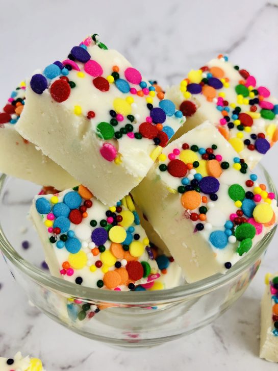 Sugar Cookie Fudge is a rich and creamy vanilla cookie dough fudge recipe. Made from eggless sugar cookie dough, this easy fudge tastes just like sugar cookies! This no bake fudge comes together quickly and will soon be your new favorite for Valentine's Day or any holiday!