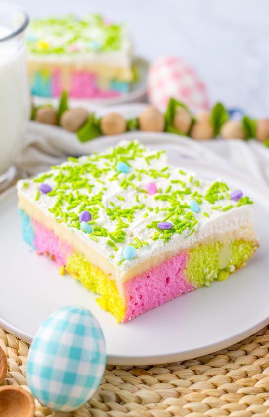 Simple holiday Easter Poke Cake is the prettiest, tastiest dessert for spring! This was such an easy and super fun cake to make! It’s the perfect sweet treat for Easter! Cake mix, white chocolate pudding layer and whipped cream on top.