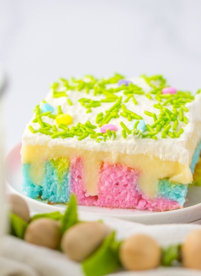 Easter Poke Cake is the prettiest, tastiest dessert for spring! This was such an easy and super fun cake to make! It’s the perfect sweet treat for Easter! Cake mix, white chocolate pudding layer and an amazing whipped cream spread on top! 