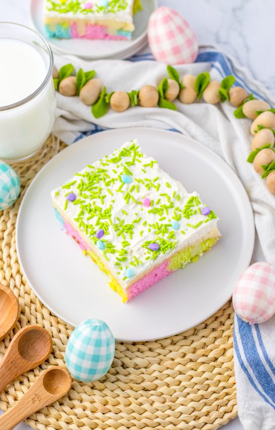 Easy Easter Poke Cake is the prettiest, tastiest dessert for spring! This was such an easy and super fun cake to make! It’s the perfect sweet treat for Easter! Cake mix, white chocolate pudding layer and whipped cream on top.