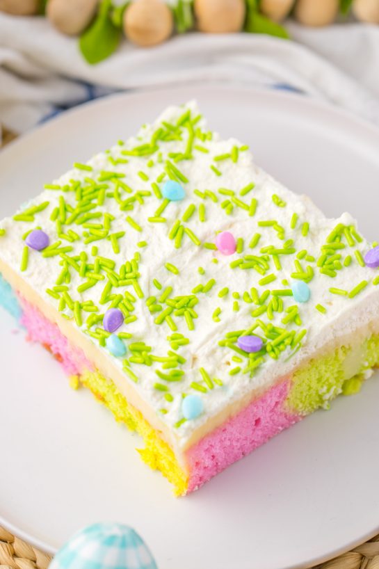 Easter Poke Cake is the prettiest, tastiest dessert for spring! This was such an easy and super fun cake to make! It’s the perfect sweet treat for Easter! Cake mix, white chocolate pudding layer and whipped cream to top it off!