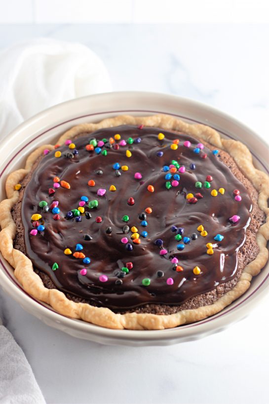 Cosmic Brownie Pie recipe is a small slice chocolate heaven. This pie is wonderfully decadent and don’t forget a glass of cold milk or vanilla ice cream to top it off! Cosmic Brownie Pie is true dessert nirvana with its flakey and buttery crust and rich, fudgy center.