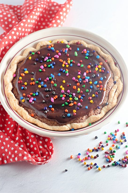 Cosmic Brownie Pie recipe is a small slice heaven. This pie is wonderfully decadent and don’t forget a glass of cold milk or vanilla ice cream to top it off! Cosmic Brownie Pie is true dessert nirvana with its flakey and buttery crust and rich, fudgy center.