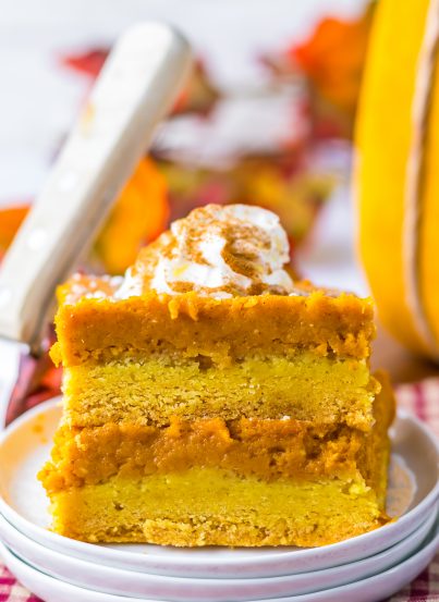 Pumpkin Gooey Butter Cake recipe is always a classic and I swear it is better than pumpkin pie.  It is even better than pumpkin pie and always a favorite in Fall and around the holidays.  A simple crust made from a yellow cake mix get topped with the most luscious pumpkin filling of pumpkin, butter, cream cheese and powdered sugar. A sprinkle of powdered sugar and a dollop of whipped cream makes this cake a showstopper.