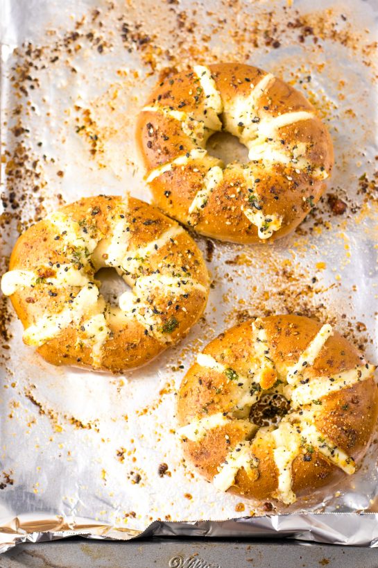 These Tik Tok Stuffed Bagels are going viral and there is a good reason! Bagels are sliced and stuffed with a sweetened cream cheese. They are brushed with a garlic butter and sprinkled with parmesan cheese before getting baked in the oven.  These totally take bagels to a whole new level.  This includes the directions for the air fryer, as well.