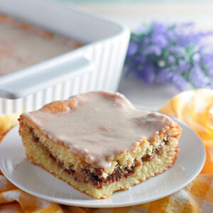 This Honey Bun Cake recipe made with yellow cake mix, sour cream, and chopped pecans is a Southern-inspired dessert that tastes just like a warm bakery honey bun! Perfectly moist, swirled with brown sugar and cinnamon, this easy doctored cake mix recipe comes together in minutes — no fancy baking skills required.