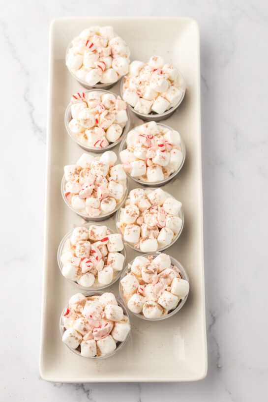 Adding the crushed peppermint to the mixture of Bailey's Irish cream with the chocolate pudding mix for the hot chocolate pudding shots recipe