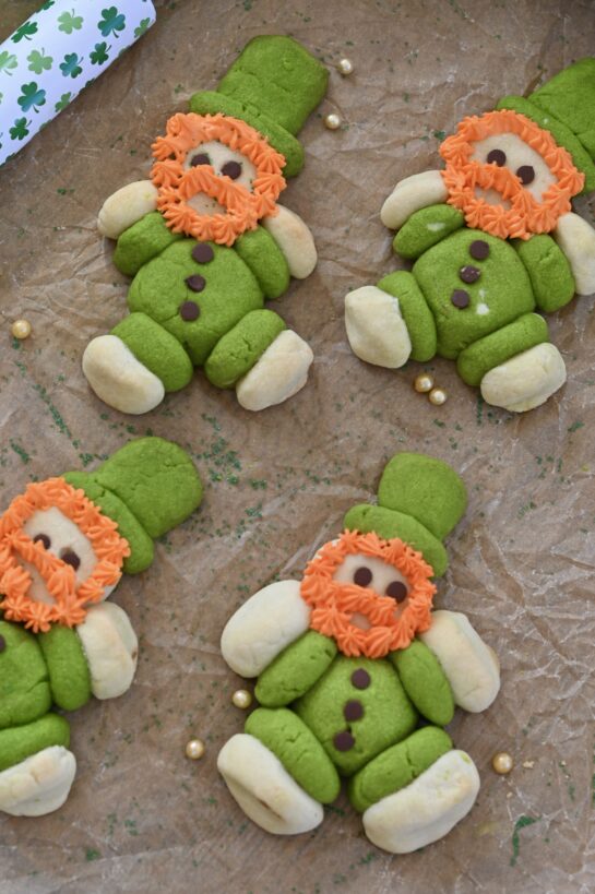Lucky Leprechaun Cookies made with green and white sugar cookie dough, mini chocolate chip buttons, and fluffy orange frosting beards. These cute, chubby St. Patrick's Day leprechaun cookies are a fun, festive, and easy holiday dessert recipe perfect for parties, kids, and St. Patrick’s Day baking. 